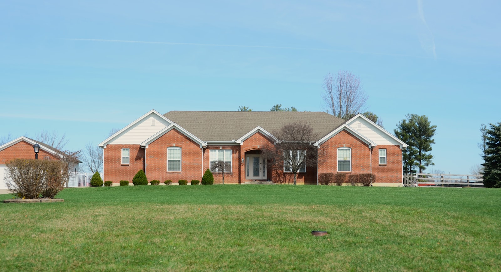 Brick single-family home with a manicured lawn